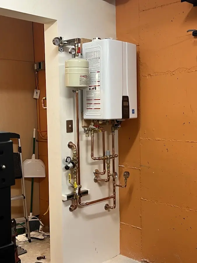 Plumbing technician inspecting water heater connections in Cibolo